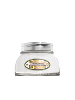 Glass jar of milk concentrate with a silver lid on a white background